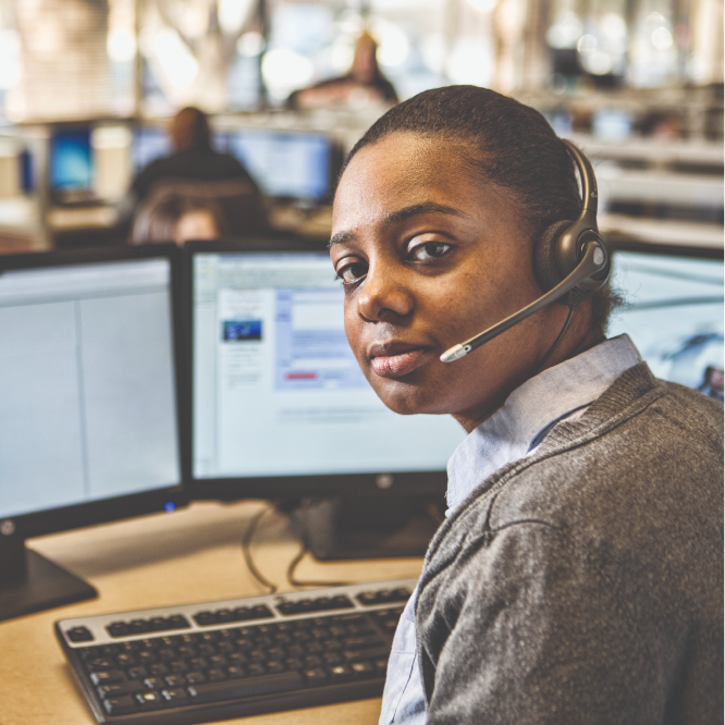 Woman sitting at desk with headset on.